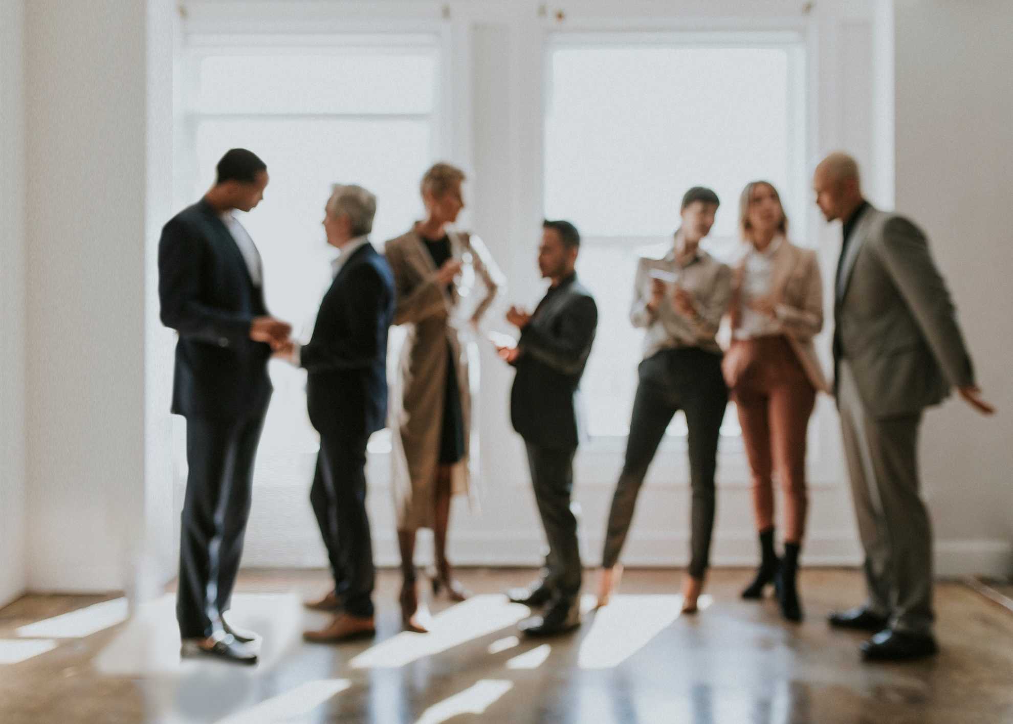 blurred image of business people in school board meeting standing and talking