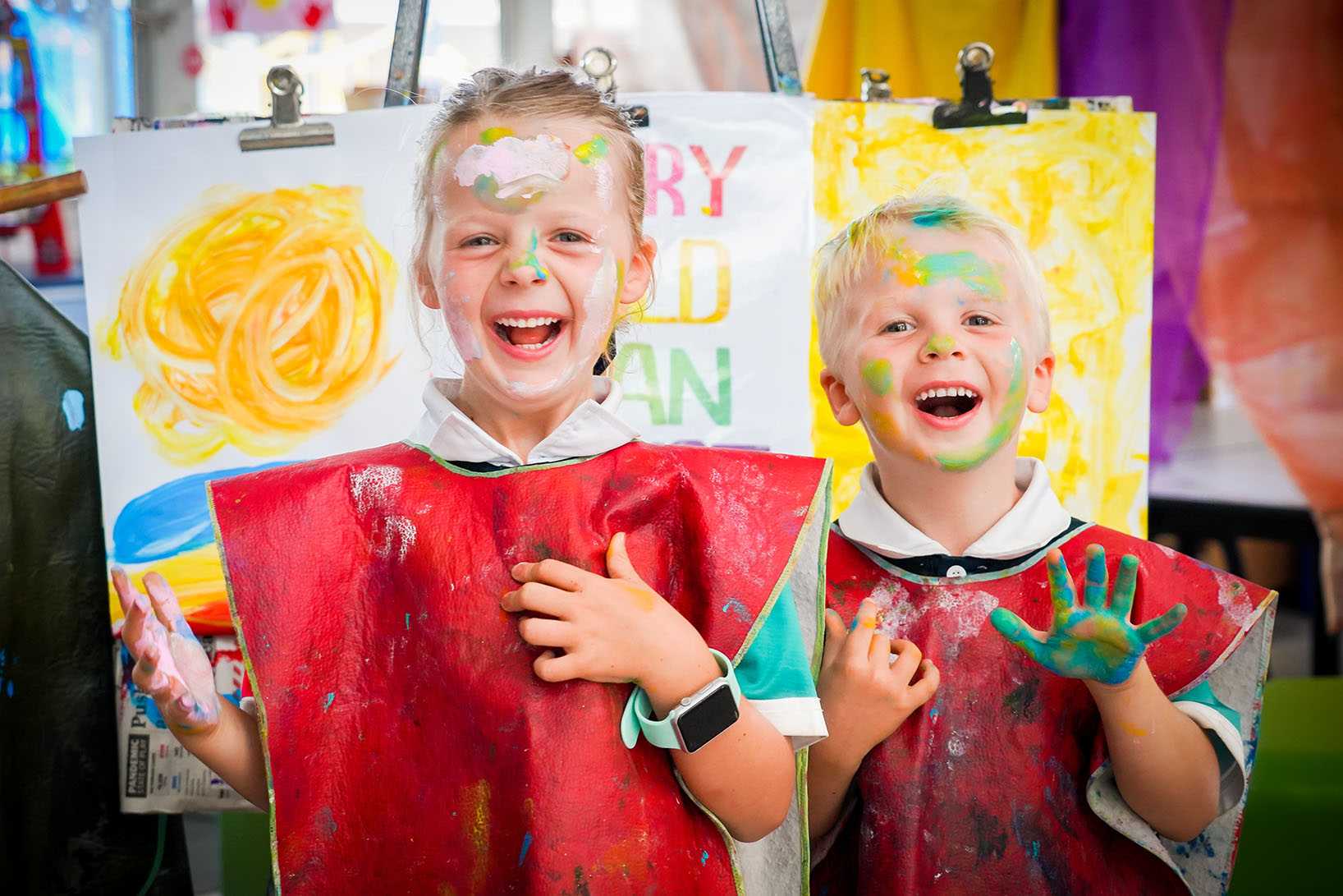 boy and girl covered in paint doing art at smartplay early learning center