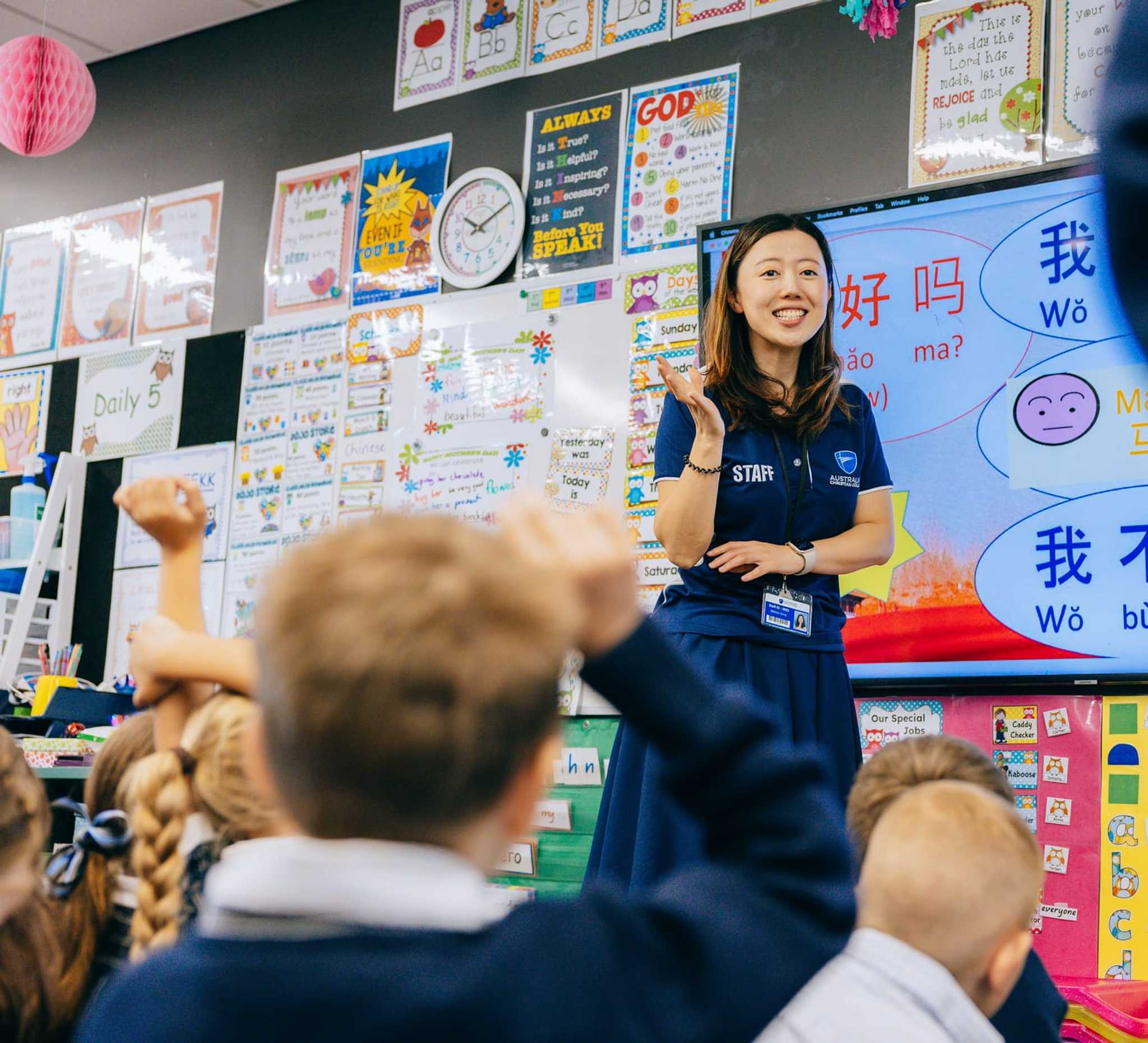 happy female teacher on internship teaching Chinese to enthusiastic students